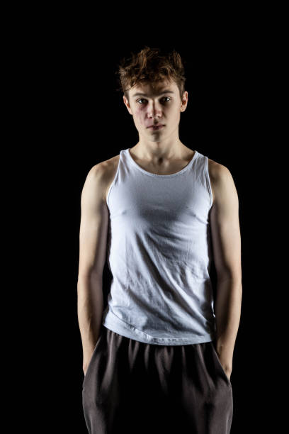 A 17 year old teenage boy wearing a white tank top