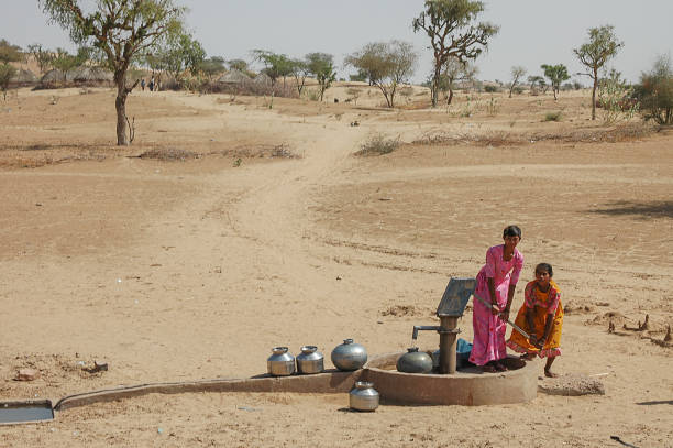 Rajasthan, India - March 13, 2006: Young people extracting water from a well in a rural area of the region