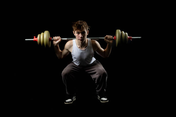 Close-up shot of Slim Asian Man Exercising  with Barbell.Concept: upper body workout, barbell exercise, strength training, Asian man fitness, muscle building, gym barbell workout, personal fitness, weightlifting routine, resistance training, arm and shoulder workout, squat workout, lower body workout