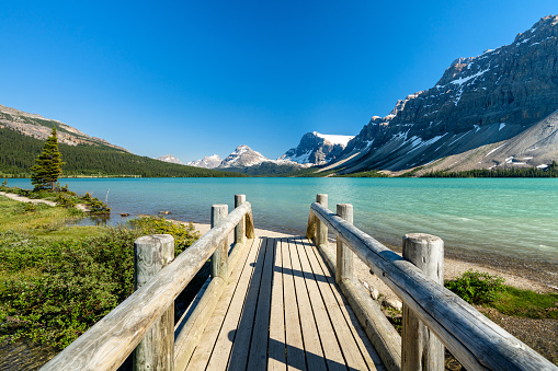 Banff National Park beautiful landscape. Bow Lake lakeshore trail and wooden bridge. Alberta, Canada. Canadian Rockies nature scenery.