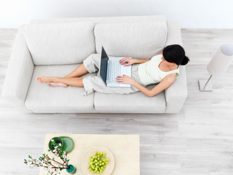 High angle view of a businesswoman using laptop on sofa
