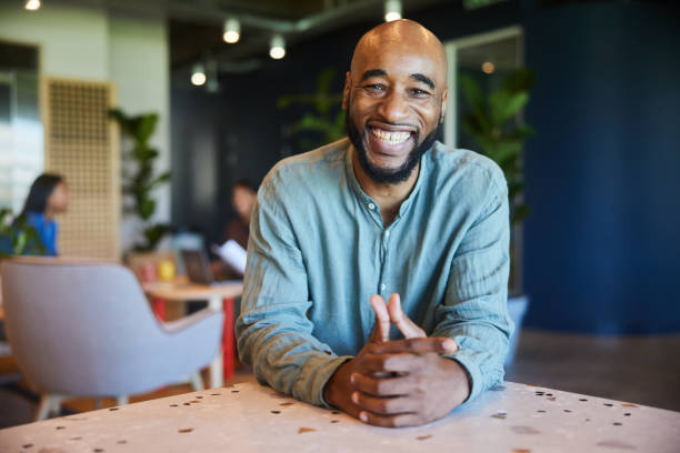 istock Laughing businessman leaning on a table in an office lounge 1467897200