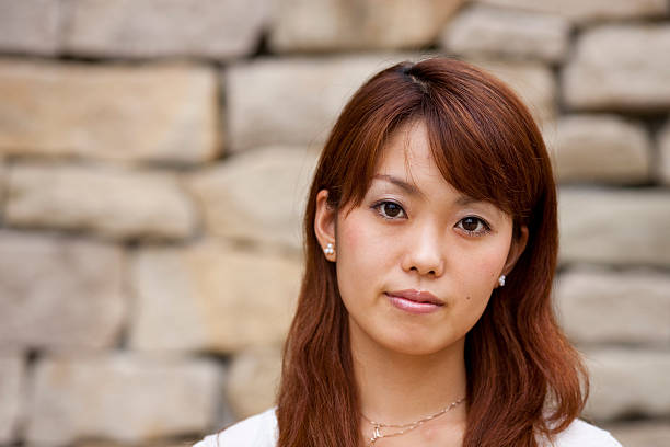 A young Japanese woman tilts her head and stares at the camera (Adobe RGB)