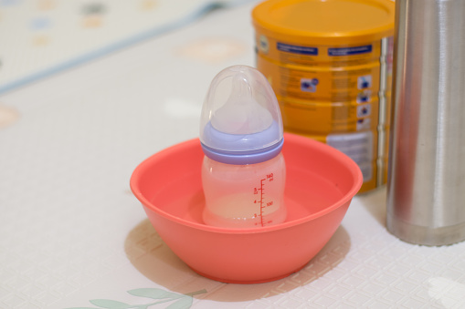 Cooling Baby Bottle in a Water Container