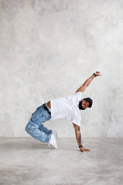 istock Man dancing break dance against background of gray wall in studio. Cool guy dancer, copy space 1467900487