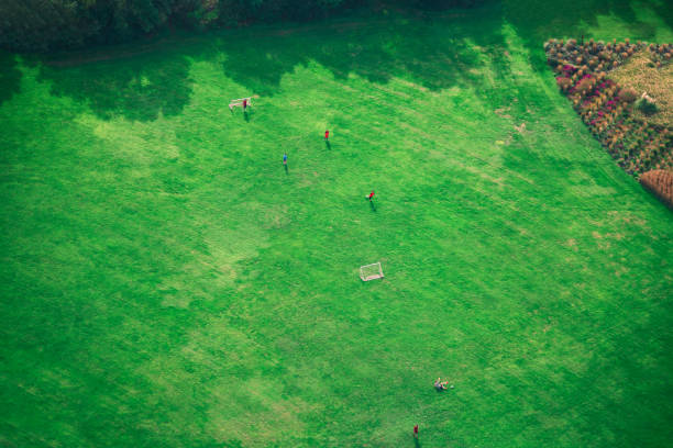 Soccer field in the park aerial view . Children playing football in park