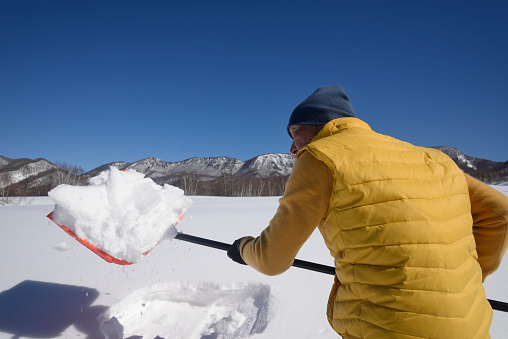 Senior man removing snow