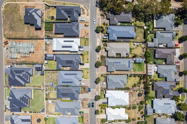 istock Aerial view directly above new rural housing development, mostly grey roofing, some green landscaping, trees 1467902080