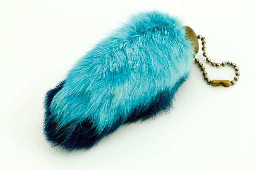 A dark and light blue rabbit's foot on a chain.