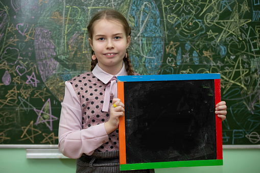 Schoolgirl of middle school age with an empty slate board.