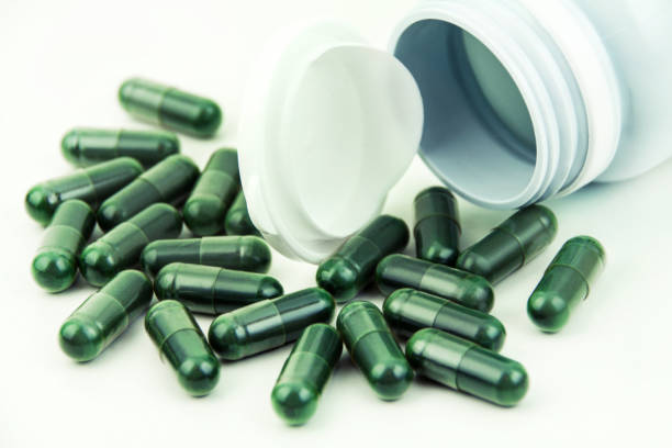 istock Green Spirulina capsules and box close up 1467904308