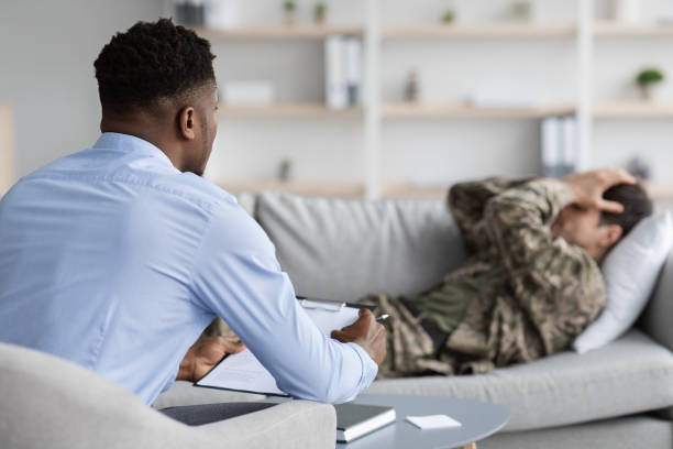 istock Upset guy soldier laying on couch while therapy session, crying 1467904450