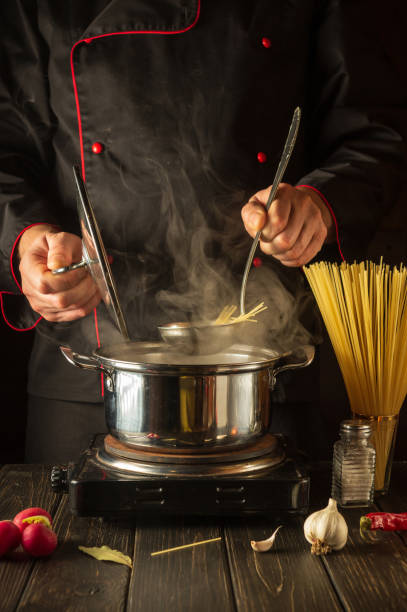 istock Cooking delicious soup for lunch. Working environment in the kitchen. Chef cooking spaghetti in a pot 1467904902