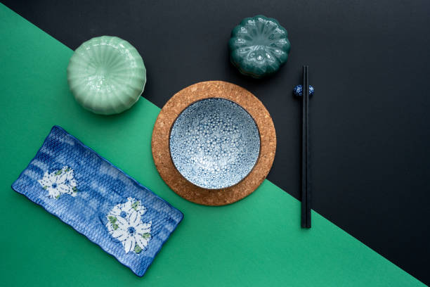 緑と黒の背景に伝統的なテーブルマットと食器を使った日本または中国のテーブルセッティング。