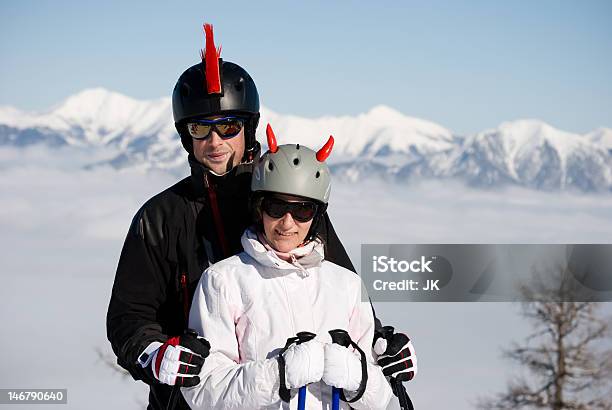 Sonriente Pareja En El Complejo Turístico De Esquí Foto de stock y más banco de imágenes de Abrazar - Abrazar, Accesorio de cabeza, Adulto