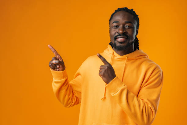 istock African man with beard pointing to copy space against yellow background 1467907436