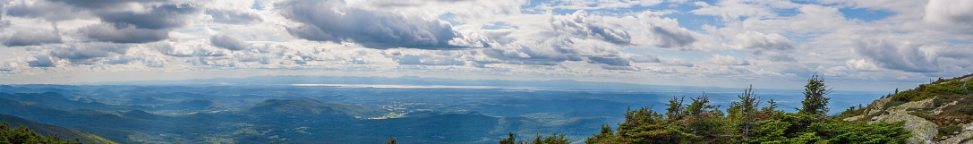 Dramatic cloudscape over Vermont rural valley with Lake Champlain in distance.