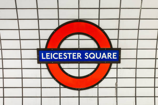 segno della metropolitana di leicester square blu e rosso su sfondo di piastrelle bianche, stazione della metropolitana a londra, regno unito - london underground foto e immagini stock