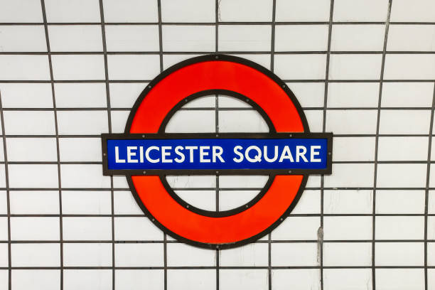 Leicester Square underground sign blue and red on white tiles background,metro station in London, UK stock photo
