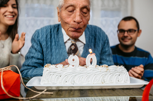Senior man celebrating birthday at home with his grandkids.