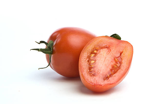 Juicy Tomatos Saladet One sliced Saladet tomato in front of a whole one over a white seemless background. two objects vegetable seed ripe stock pictures, royalty-free photos & images