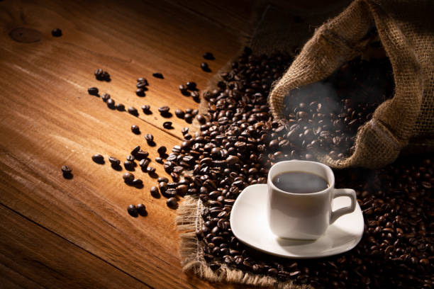 istock Coffee break background. Hot coffee in cup and roasted coffee beans on a wooden table. Copy space 1467909912