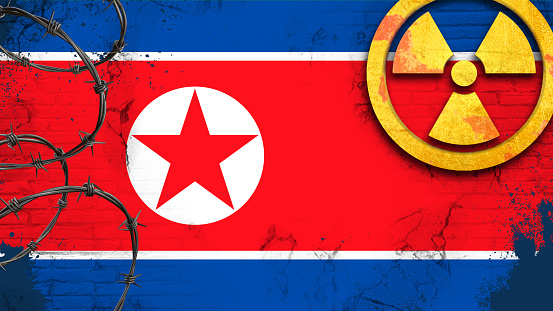 North Korean flag with radiation symbol. Radioactive contamination symbol. Nuclear war danger.