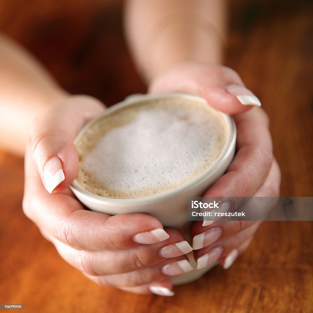 Чашку капучино кофе на деревянный стол в руки - Стоковые фото Без людей роялти-фри
