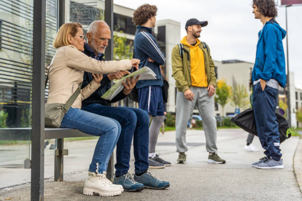 istock Couple sitting at bus stop 1467916207