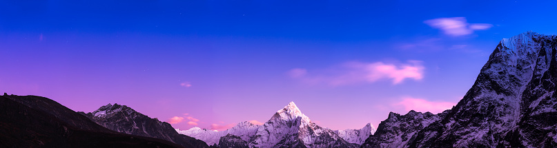 Stars shining over the snow capped peak of Ama Dablam deep in the Himalaya mountains of Nepal.