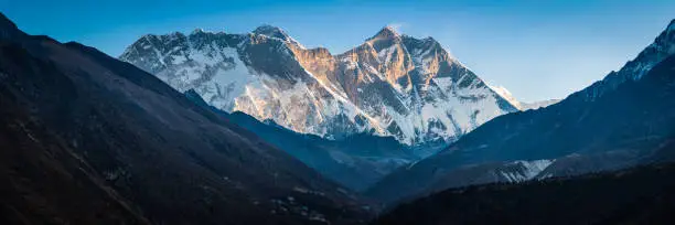 The massive South Faces of Nuptse (7861m) and Lhotse (8516m) overlooked by Mt. Everest (8848m) high in the Himalayan mountain wilderness of Nepal.