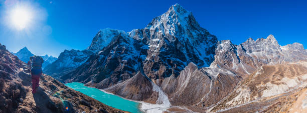 istock Sun flaring over Sherpa on dramatic Himalayan mountain path panorama 1467918831