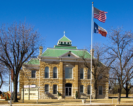 Courthouse built in 1890 in Throckmorton Texas with flags.