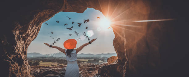Freedom, Chain - Object, Breaking, Free of Charge, Bird, Change, Concepts, Recovery, New Life, Wellbeing,Cave The woman is breaking the chains and setting the birds free, in a cave at the top of a mountain enjoying the nature at sunrise. concept of freedom breaking free from chains stock pictures, royalty-free photos & images