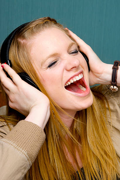 Bella giovane donna cantare con cuffie - foto stock