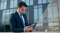 istock DS Business man standing outside the modern business building and using home control app on his tablet 1467928039