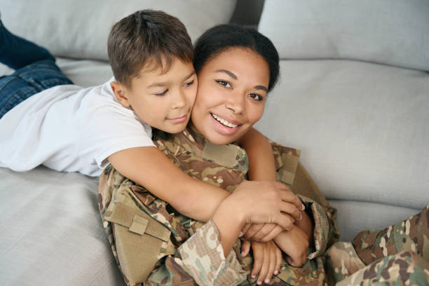 istock Boy hugs his mother by neck, they are located on sofa 1467929800