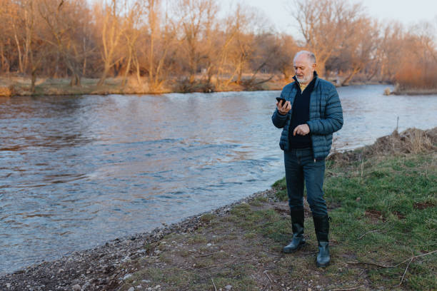 istock Senior man with a black smartphone in the nature 1467930107