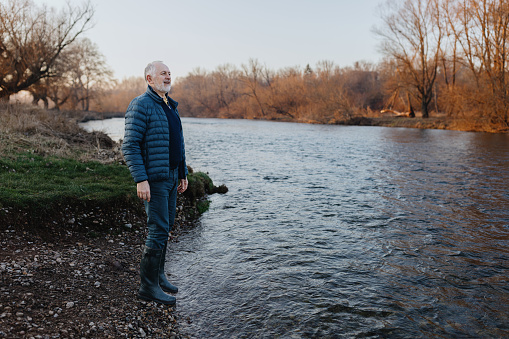 Adult businessman enjoying the river view in the nature