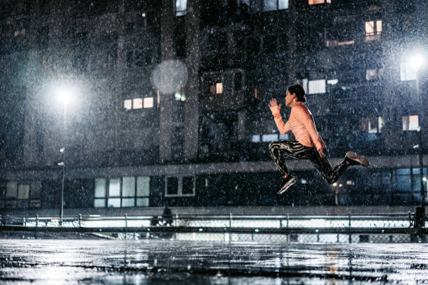 istock Young Woman Jumping In The Rain At Night 1467930378