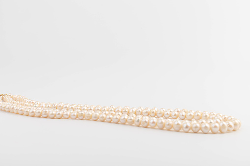 Pearls on white background with copy space. Necklace Jewelry.