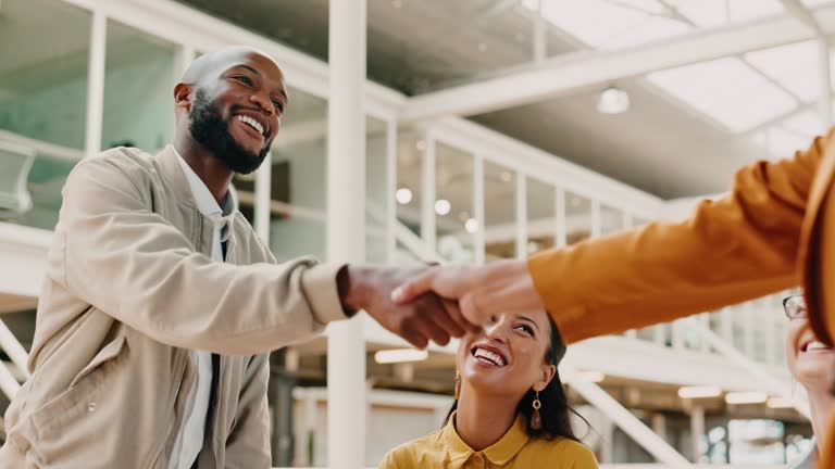 Handshake, partnership and business people in office with a deal, agreement or greeting. Meeting, corporate and professional employees shaking hands for welcome, onboarding or thank you in workplace.
