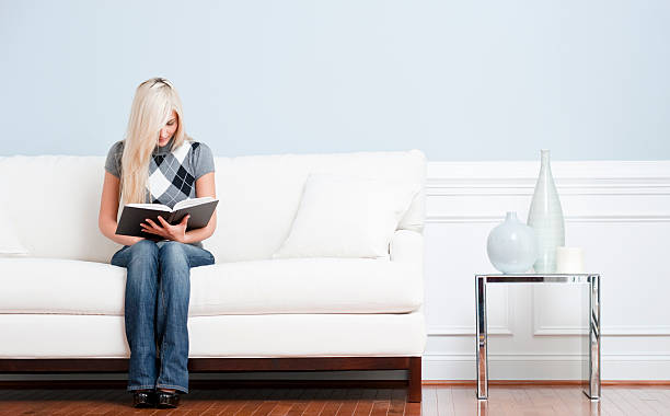 istock Woman Sitting on Couch and Reading Book 146793211