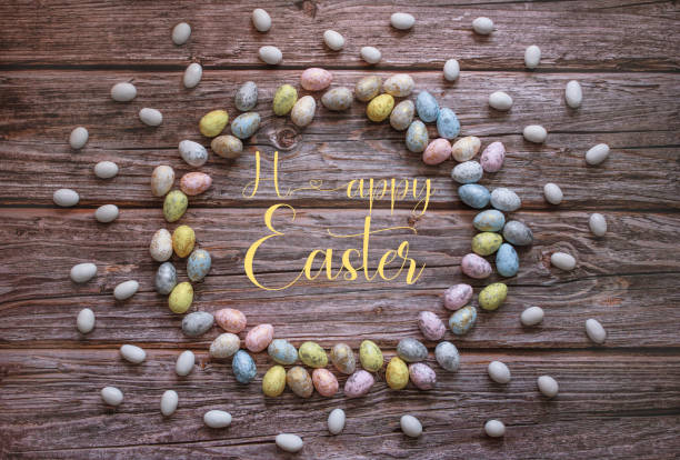 Easter garland, made of Easter eggs, on wooden background  with Happy Easter text in the middle. Copy space. Top view. Greeting card.