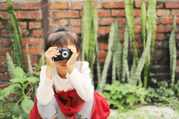 a Asian girl taking pictures in the alley next to the old house
