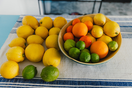 High-angle view of multi-coloured lemons, limes and oranges on the blue table in authentic Mediterranean kitchen