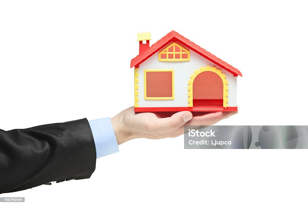 agent nieruchomości trzyma model domu - Zbiór zdjęć royalty-free (Agent nieruchomości)