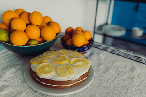 A view of lemons, limes and oranges with biscuit lemon cream cake on the table in the authentic Mediterranean kitchen in Turkey