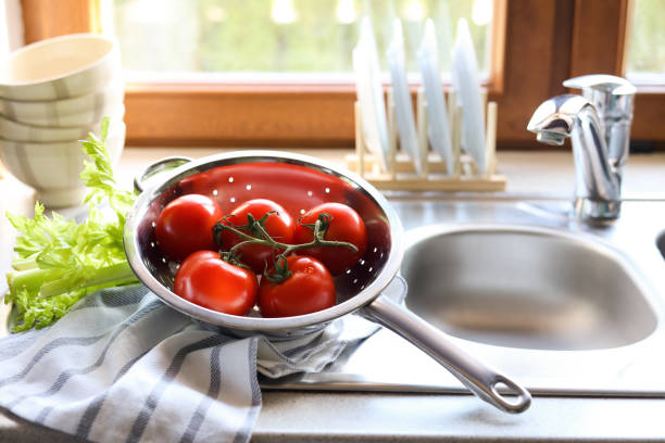 istock Colander with fresh raw tomatoes and celery near sink in kitchen 1467937716