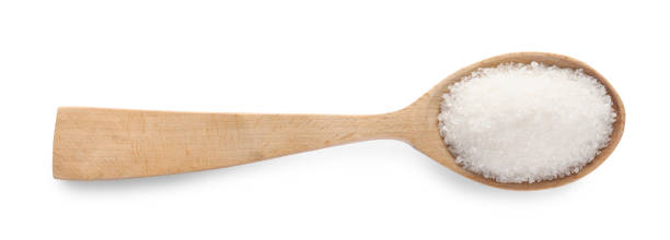 istock Granulated sugar in wooden spoon isolated on white, top view 1467937740